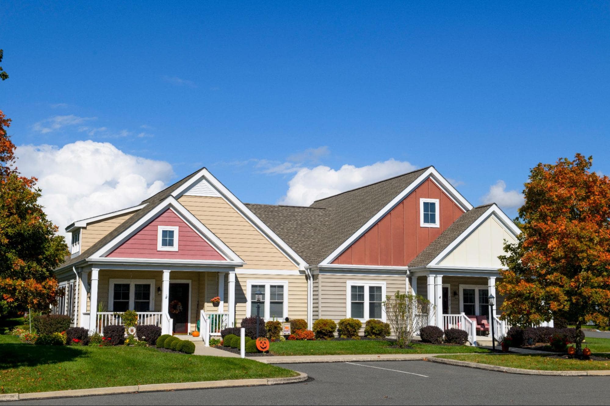 Exterior view of colorful single-story cottages at an independent living retirement community on a bright day.